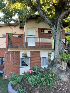 a building with a tree in front of it at Cabaña 3 del Puerto Gol in Santo Tomé