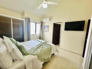 a bedroom with a bed and a flat screen tv at Bright & Modern Apartment in Puerto Plata, Secure, and Central! in San Felipe de Puerto Plata