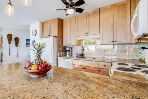 a kitchen with a bowl of fruit on a counter at Kihei Alii Kai Ocean View Condo Pool, Hot Tub, Sauna, AC, Sleeps 4 in Kihei