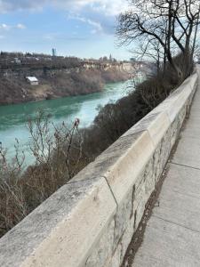 a stone retaining wall next to a river at Dougs house in Niagara Falls