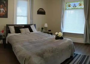 a bedroom with a large bed and two windows at Dougs house in Niagara Falls