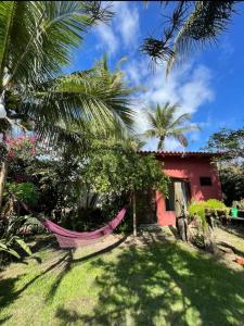 a hammock in front of a red house at Casa das Flores in Prado