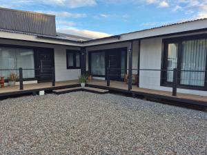 a house with black windows and a gravel driveway at Complejo Del Este Suites in San Carlos de Bariloche