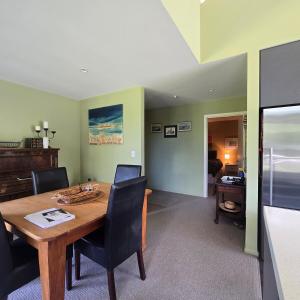 a dining room with a wooden table and chairs at Riverside Retreat in Twizel