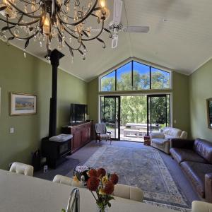 a living room with a couch and a chandelier at Riverside Retreat in Twizel