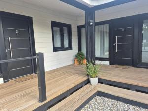 a porch with black doors and a potted plant at Complejo Del Este Suites in San Carlos de Bariloche