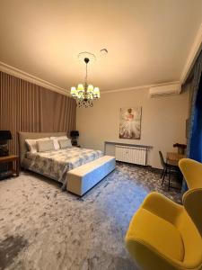 a bedroom with a bed and two chairs and a chandelier at Villa Chamare in Pero