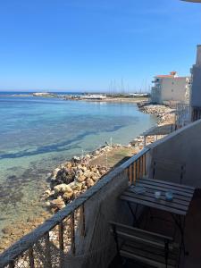 a balcony with a bench and a view of the water at La terrazza sul mare, 44 in Marzamemi