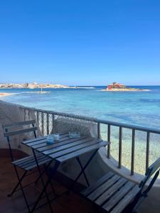 a table and chairs on a balcony overlooking the ocean at La terrazza sul mare, 44 in Marzamemi