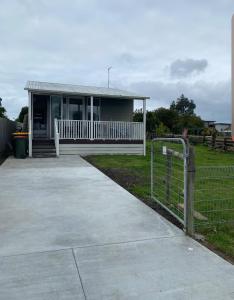 a small house with a fence in front of it at Coronet Bay Beach Cabin in Coronet Bay