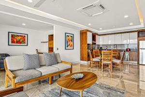 a living room with a couch and a table at Modern condo with ocean views, rooftop infinity pool & central AC in Puerto Vallarta
