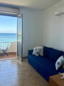 a blue couch in a living room with a view of the ocean at La terrazza sul mare, 44 in Marzamemi