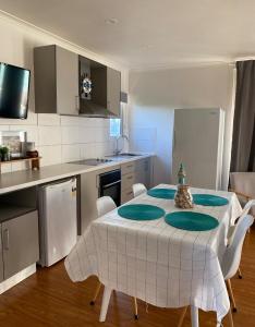 a kitchen with a table and chairs in a kitchen at Coronet Bay Beach Cabin in Coronet Bay