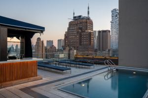 a rooftop pool with a view of a city at ModernHaus SoHo in New York