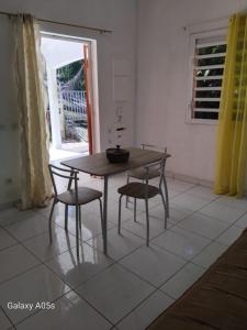 a table and chairs in a room with a window at Chez COCO in Le Gosier