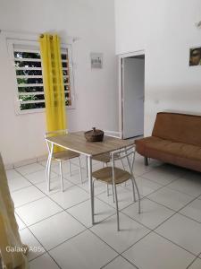 a table and chairs in a living room with a couch at Chez COCO in Le Gosier