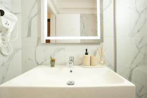 a white bathroom with a sink and a mirror at TAO Apartment 2 in Tirana +27 photos