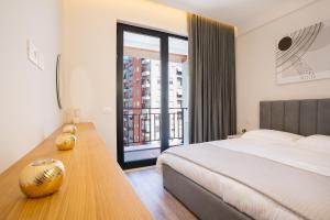 a bedroom with a bed and a desk with a window at TAO Apartment 2 in Tirana