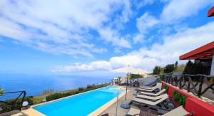 a swimming pool with a view of the ocean at Madeira Native Motion Guest House in Fajã da Ovelha