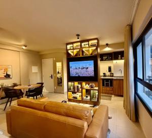 a living room with a couch and a flat screen tv at Studio moderno e confortável no Marista in Goiânia