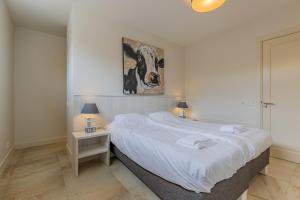 a bedroom with a large bed and a painting on the wall at Binnenduyn 2 in Buren