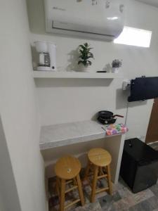 a small kitchen with two stools and a counter at Depa 1 sf2 in Hermosillo +34 photos