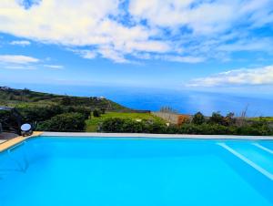 a swimming pool with a view of the ocean at Madeira Native Motion Apartment in Ponta do Pargo