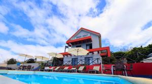 a building with a pool in front of a resort at Madeira Native Motion Apartment in Ponta do Pargo