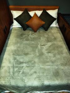 a bed with several pillows on top of it at Cabañas La Cascada in Tepoztlán