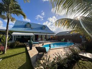 a house with a swimming pool in the yard at Villa Caillou in Lamentin