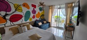 a bedroom with a bed and a painting on the wall at STUDIO La Diamantinoise in Le Diamant
