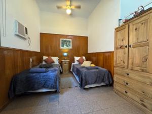 a bedroom with two beds and a dresser at Apto Mitre in San Juan