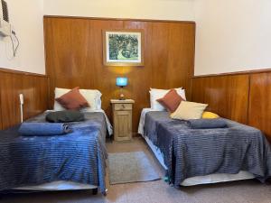two beds in a room with wood paneling at Apto Mitre in San Juan