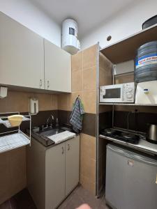 a small kitchen with a sink and a microwave at Apto Mitre in San Juan