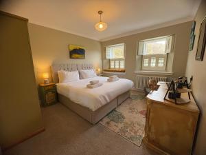 a bedroom with a large white bed and two windows at Cuilcheanna House - near Glencoe - room only or breakfast available in Onich