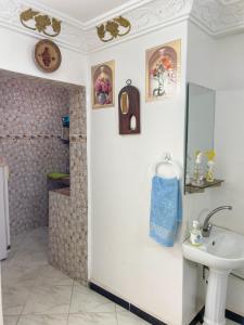 a bathroom with a sink and a mirror at Dallas Surf Apartment in Agadir +16 photos