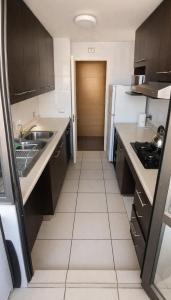 a small kitchen with a sink and a refrigerator at Departamentos Mar Egeo in Iquique