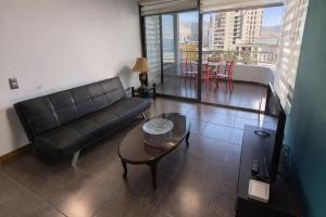 a living room with a couch and a table at Departamentos Mar Egeo in Iquique