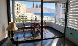 a balcony with a table and chairs and a view of the ocean at Departamentos Mar Egeo in Iquique