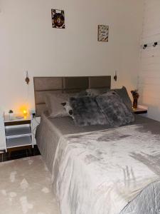 a bedroom with a large bed and a side table at Kit luxo com spa aquecido in Florianópolis