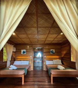 a bedroom with two beds in a log cabin at Camp Olli Beach Villas in Dapa