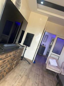 a living room with a flat screen tv and a chair at Residence Meuble Zac Mbao in Kammba