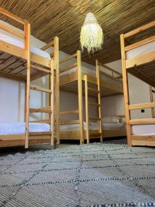 a room with three bunk beds and a chandelier at Surf Therapy in Agadir