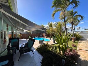 a patio with chairs and a swimming pool at Villa Caillou in Lamentin