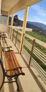 two benches on a porch with a view of a field at Casa das Quintas com vista para a montanha in Boticas