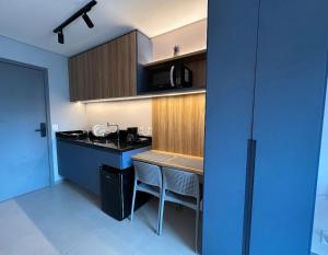 a kitchen with a counter and a blue wall at Flat Beach Class Meireles in Fortaleza