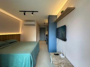 a bedroom with a bed and a tv on a wall at Flat Beach Class Meireles in Fortaleza