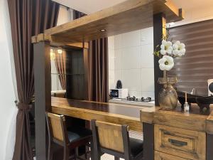 a kitchen with a counter with chairs and a table at The Bunker StudioStay in Arau