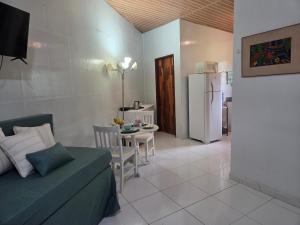a living room with a couch and a table and a refrigerator at Flat 01 Carvalhos de Aldeia km5 in Recife