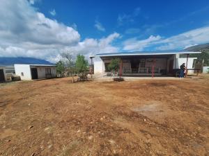 a building with a dirt yard in front of it at Cabaña Marmolejo in Arteaga